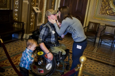 Luke Cifka, of Olympia, Wash., an Army veteran who was wounded in Afghanistan, shares a moment with his wife Kaitlin, and son Wyatt, 2, in the Senate Reception Room,December 9, 2014. (