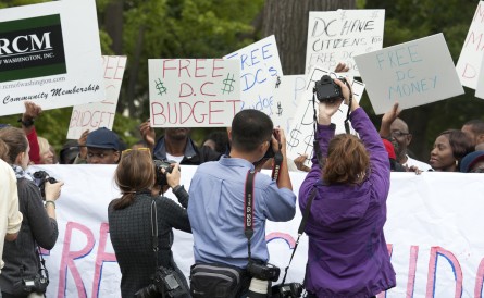 Residents of Washington, D.C. hold signs during a press conference on the DC budget during government shutdown. (Douglas Graham/CQ Roll Call)