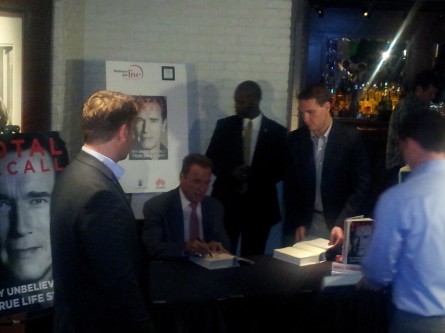 Arnold Schwarzenegger signing copies of "Total Recall"