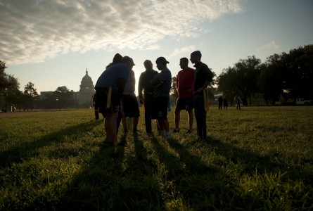Members of Congress and staffers huddle during a congressional football practice on the Mall in preparation for the upcoming game between members of Congress and the Capitol Police. (Tom Williams/CQ Roll Call File Photo)