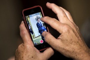 A guest uses an iPhone to take a picture while President Barack Obama speaks during an event in the East Room of the White House (Photo by BRENDAN SMIALOWSKI/AFP/Getty Images)