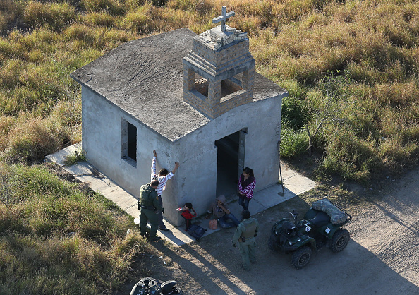 RIO GRANDE CITY, TX - DECEMBER 09: U.S. Border Patrol agents search a migrant family after they crossed the U.S.-Mexico border on December 9, 2015 near Rio Grande City, Texas. The number of Central American migrant families and unaccompanied minors crossing into Texas has again surged in recent months. (Photo by John Moore/Getty Images)