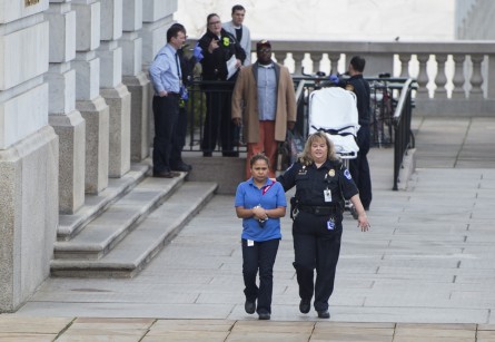 UNITED STATES - JANUARY 15: A U.S. Capitol Police officer escorts a Sodexo worker from the Longworth House Office Building after exposure to lead paint dust left workers feeling sick, Jan. 15, 2016. (Photo By Bill Clark/CQ Roll Call)