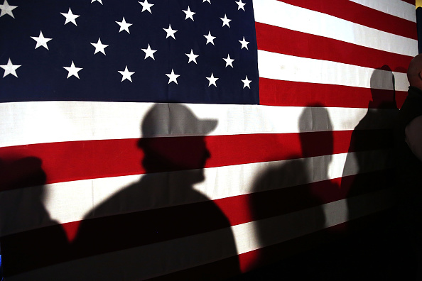 MYRTLE BEACH, SC - FEBRUARY 11: Shadows are reflected on an American Flag as people line up to speak with Ohio Governor and Republican presidential candidate John Kasich at a restaurant in South Carolina following his second place showing in the New Hampshire primary on February 11, 2016 in Myrtle Beach South Carolina. Kasich, who is running as a moderate, is expected to face a difficult environment in South Carolina where conservative voters traditionally outnumber moderates. (Photo by Spencer Platt/Getty Images)